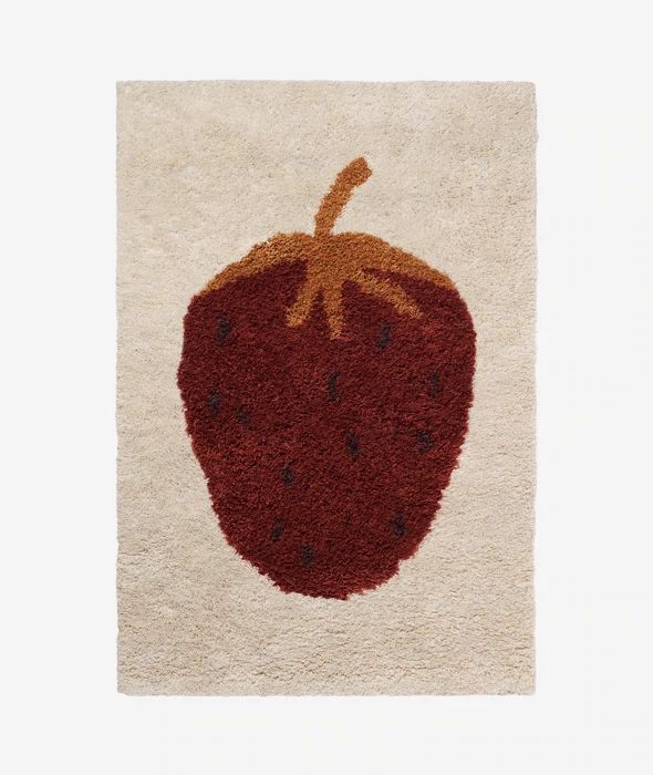 a red and white rug with a strawberry on the top, in front of a white background