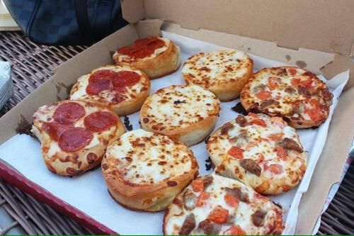 a box filled with mini pizzas sitting on top of a table