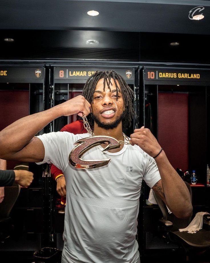 a man with dreadlocks and a white t - shirt in a locker room