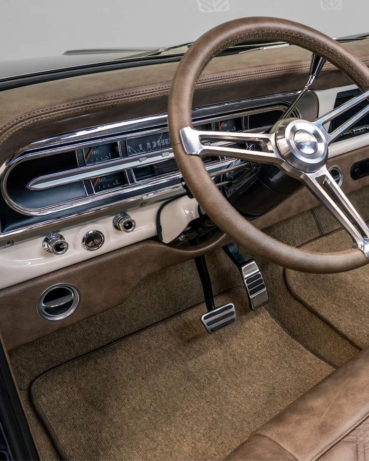 the interior of an old car with leather and chrome trims, including steering wheel