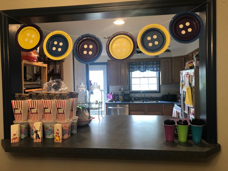 a kitchen with lots of plates hanging from the ceiling and cups in front of it