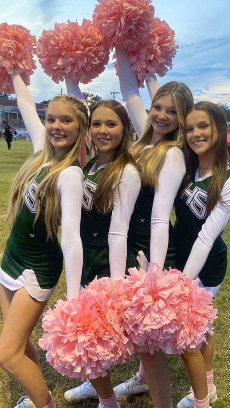 the cheerleaders are all dressed in green and pink pom - poms