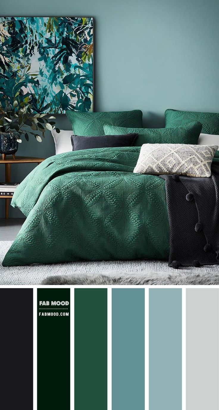 a bedroom with blue walls and green bedding in shades of teal, black, white and grey