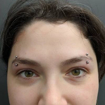 a woman with piercings on her nose looking at the camera