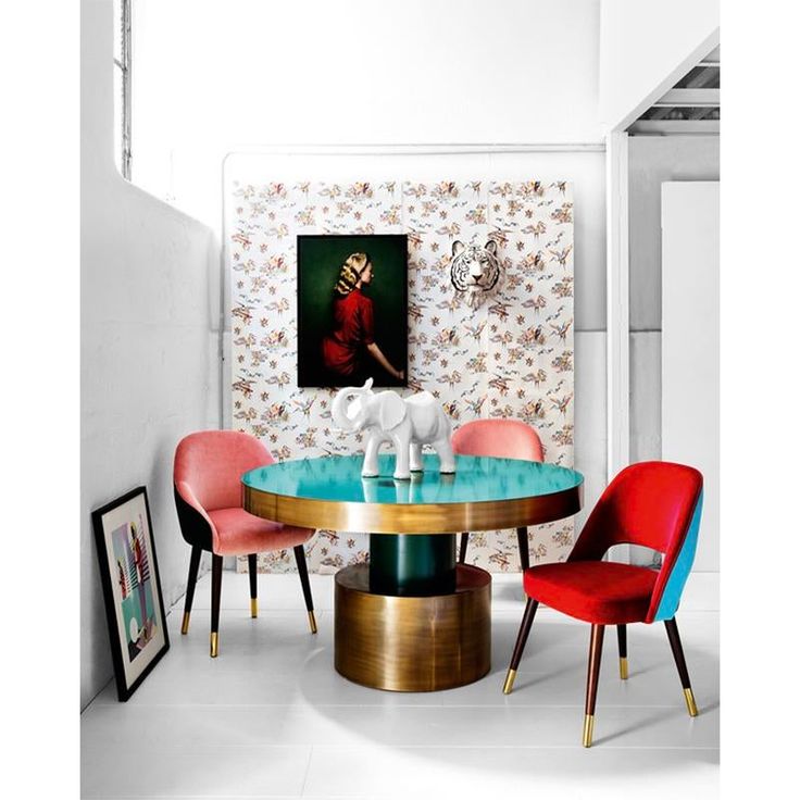 a dining room table with colorful chairs and an elephant figurine on the table