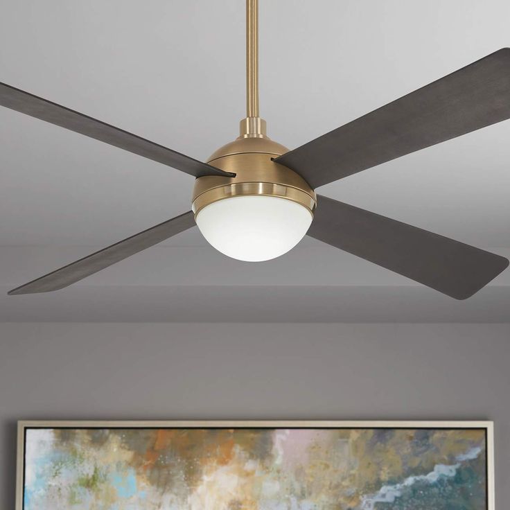 a ceiling fan in a living room with a painting on the wall