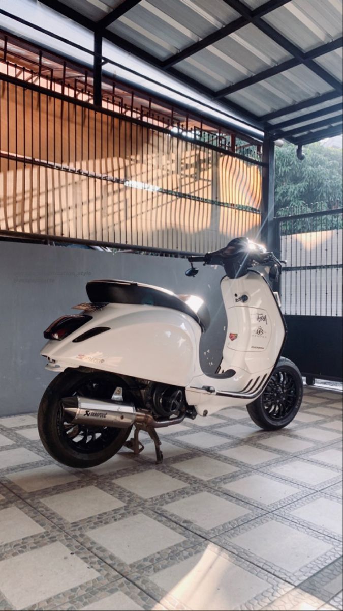 a white scooter is parked in a garage