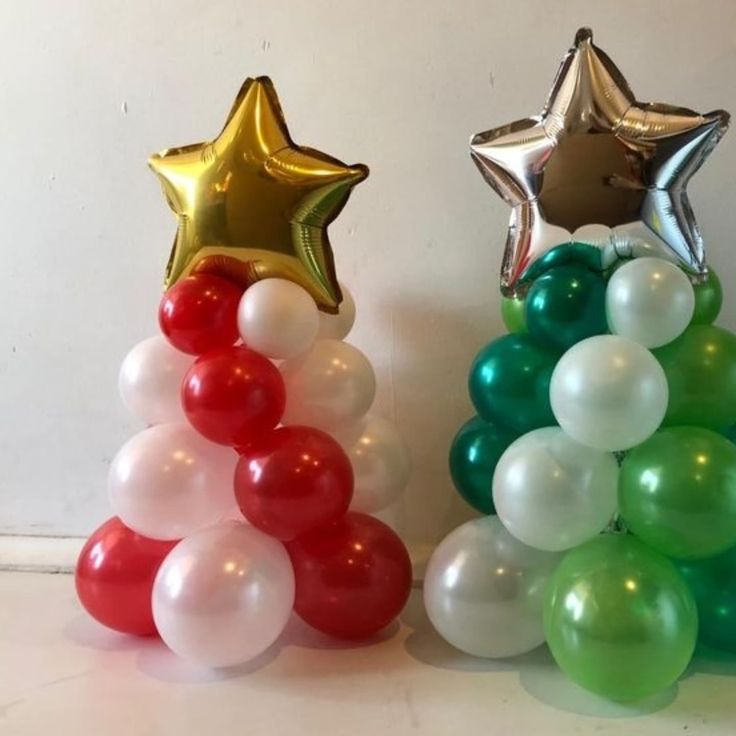 two star shaped balloons are next to each other in the shape of a christmas tree