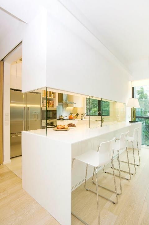 a kitchen with white counter tops and chairs