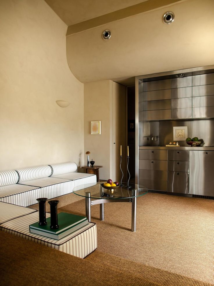 a living room filled with furniture and a metallic refrigerator freezer next to it's door