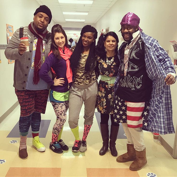 four people standing together in an office hallway