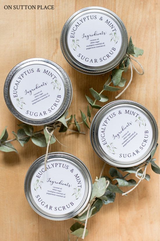 three tins with labels on them are sitting on a table next to some leaves