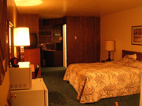 a hotel room with a bed, microwave and refrigerator