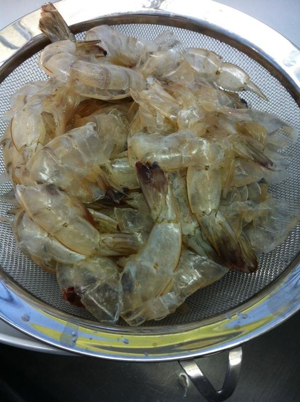 some shrimp are sitting in a strainer on the table