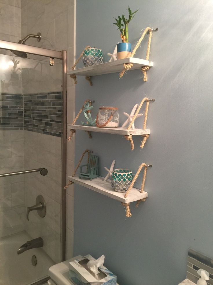 a bathroom with blue walls and shelves on the wall, along with a white toilet