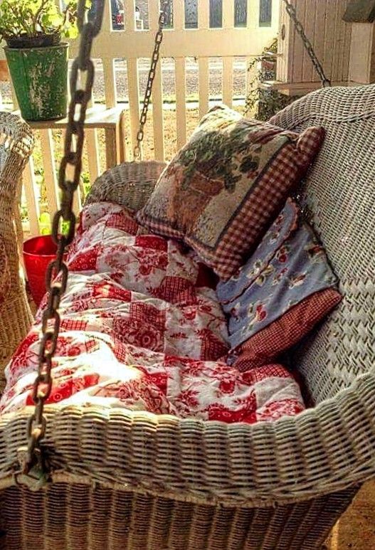 a wicker hanging chair with pillows on it