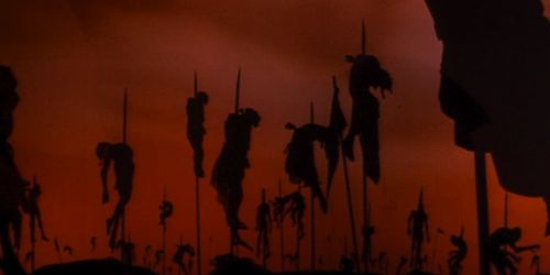 the silhouettes of people in front of an orange sky with red and black clouds