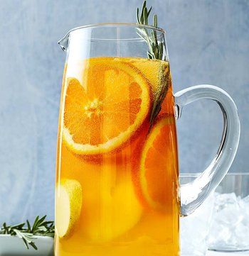 a pitcher filled with liquid and sliced oranges