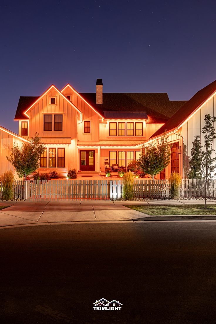 a large house lit up at night with lights on the front and side of it