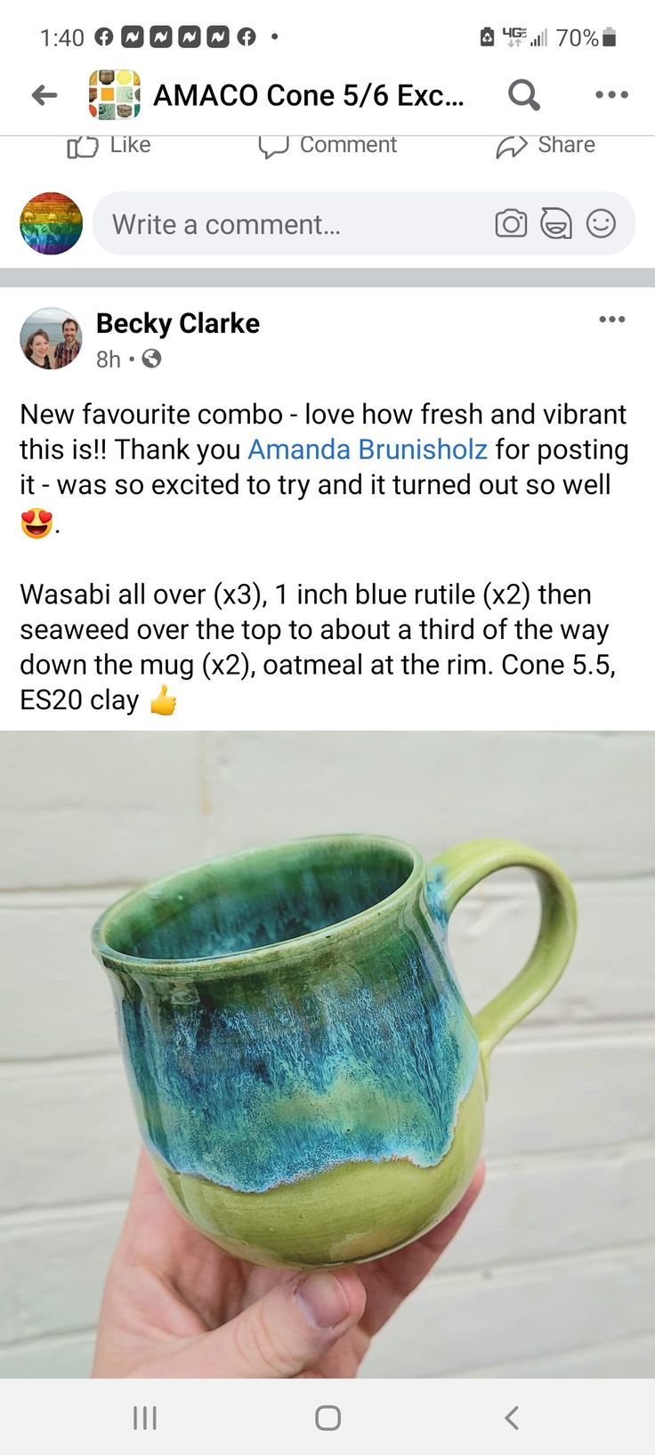 someone is holding up a ceramic cup with blue and green glaze on the inside