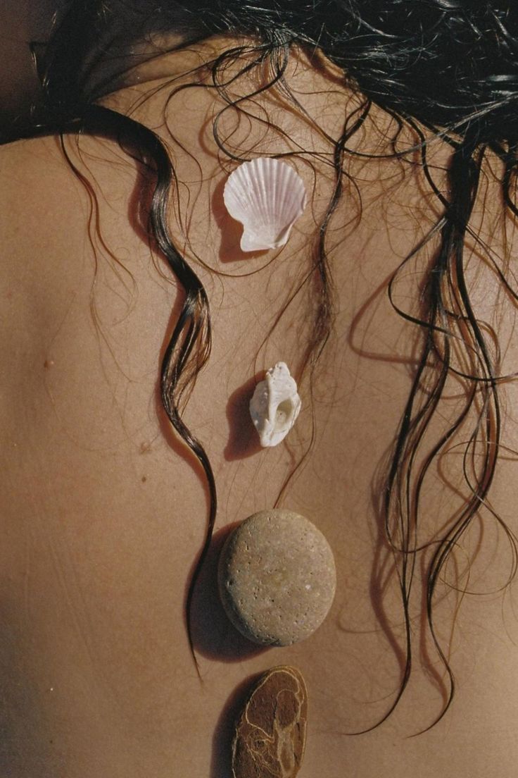 the back of a woman's head with seashells on it