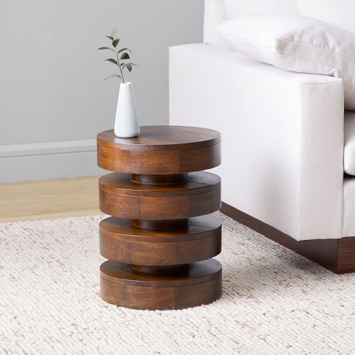 a white couch sitting next to a wooden table on top of a carpeted floor