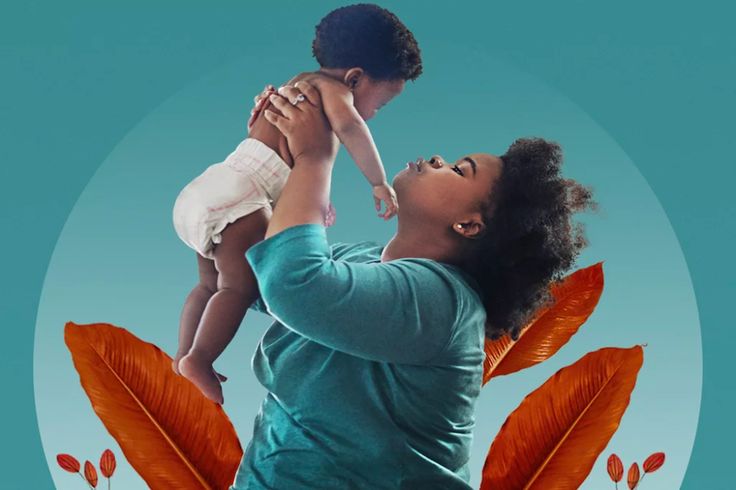 a woman holding a baby up to her face in front of an image of leaves