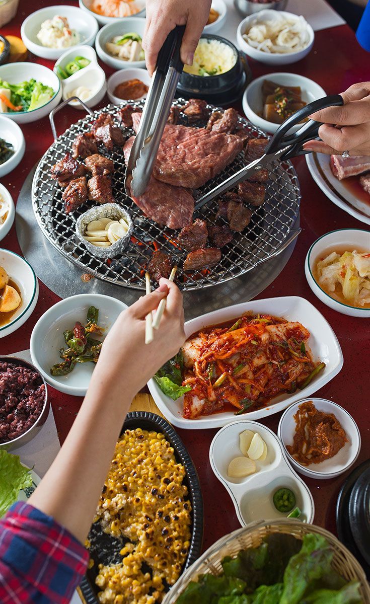 several people are preparing food on a grill