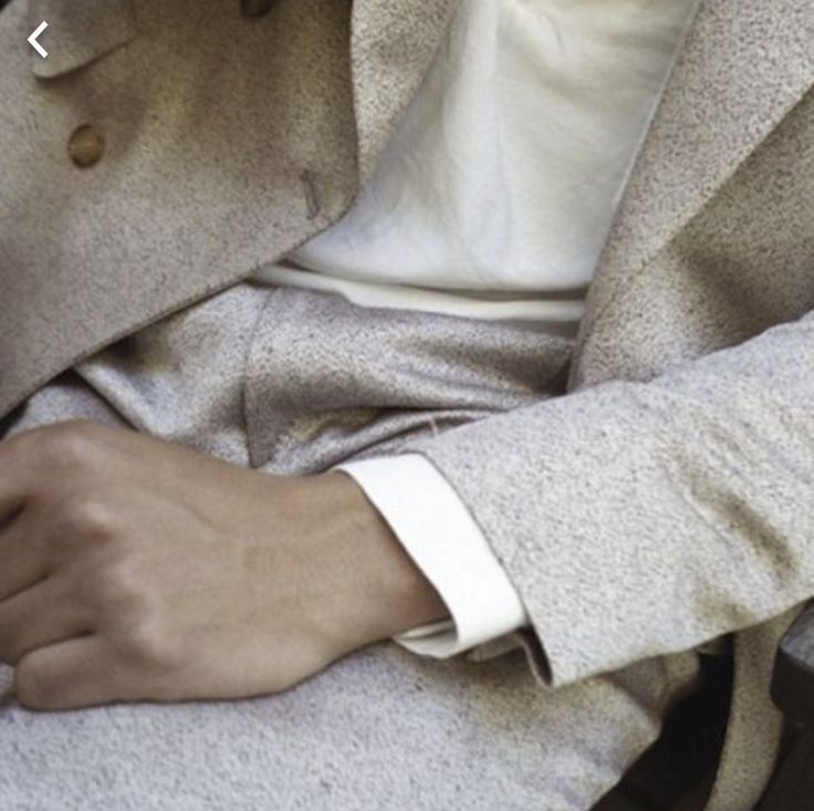 a close up of a person wearing a watch on their wrist and holding onto his jacket