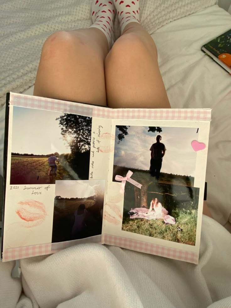 a person laying in bed with their legs crossed and holding an open photo book that has pictures of people on it