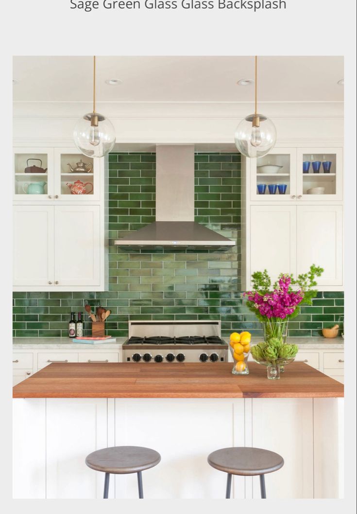 a kitchen with green glass backsplash and two stools in front of the counter