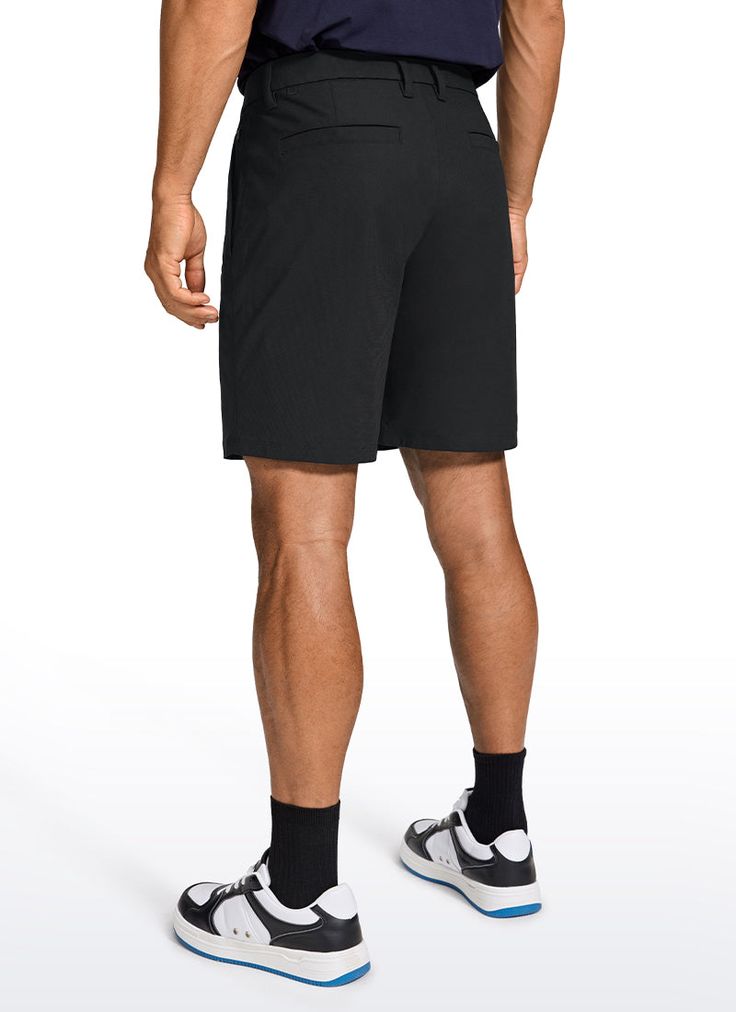 a man in black shorts is standing with his back to the camera and looking down