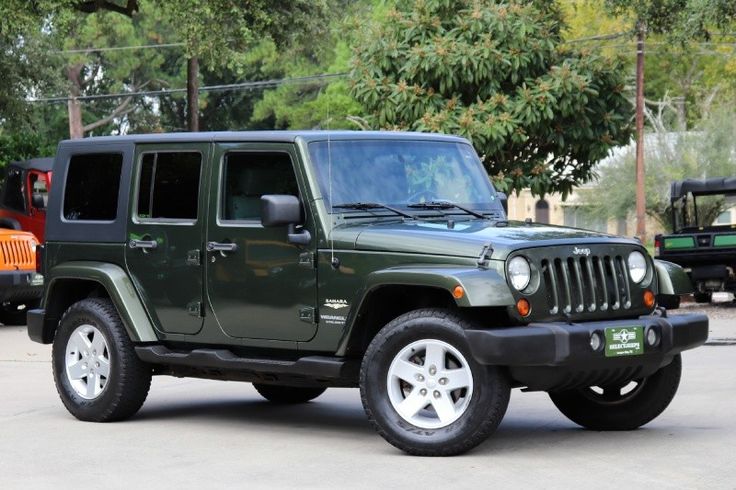 a green jeep is parked in a parking lot