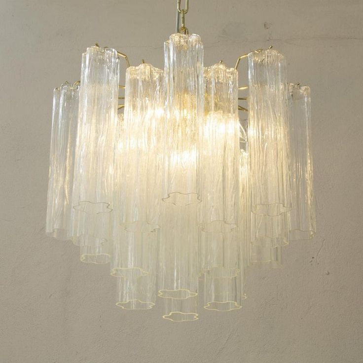 a chandelier hanging from the ceiling in a room with white walls and flooring