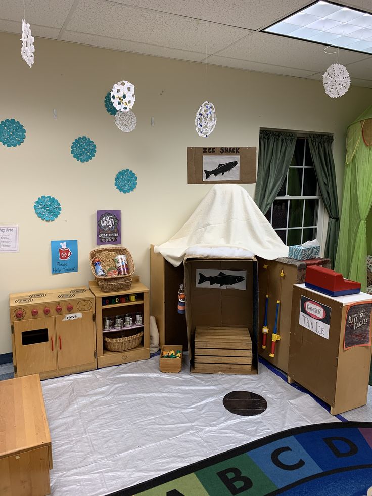 a room with cardboard boxes and toys on the floor in front of a tent that is made to look like a camper's house