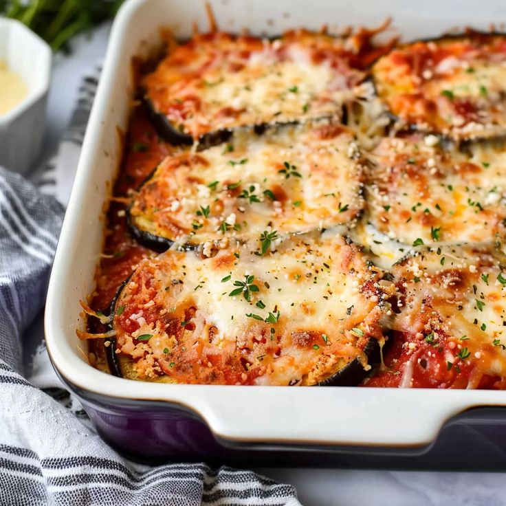 a casserole dish with zucchini, cheese and parmesan sauce