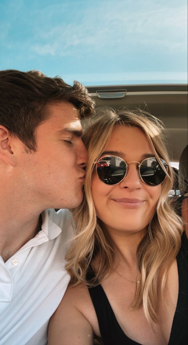 a man and woman kissing in the back of a car