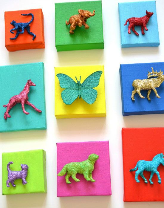 small colorful animal magnets are arranged on colored paper with butterfly and dog figurines