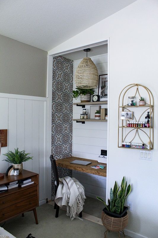 a room with a desk and shelves in it