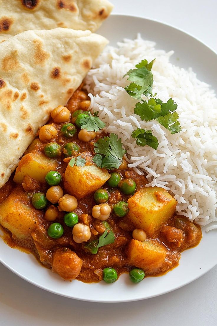 a white plate topped with rice and beans next to tortilla bread on top of a table