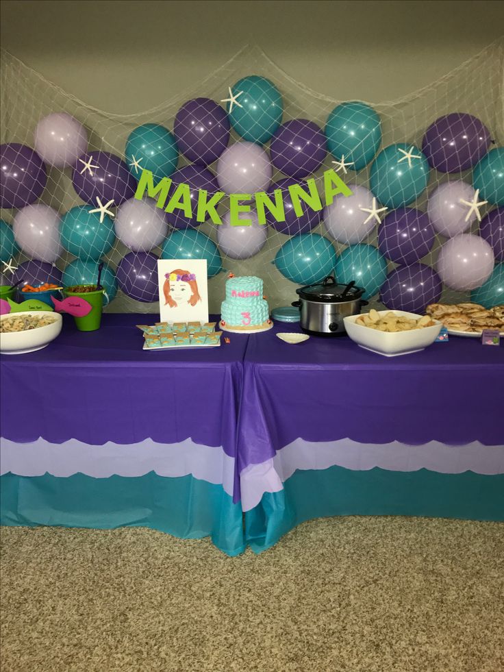 a table topped with cake and balloons next to a sign that says makenna on it