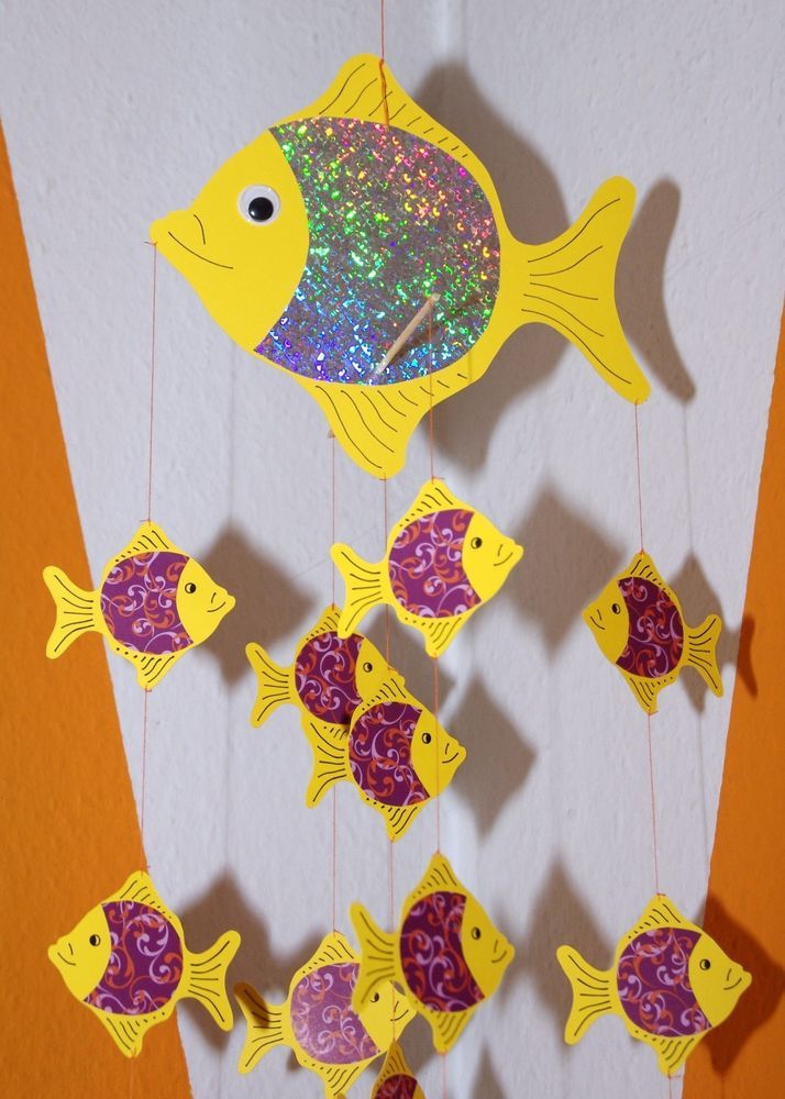 a group of fish hanging from strings on a wall