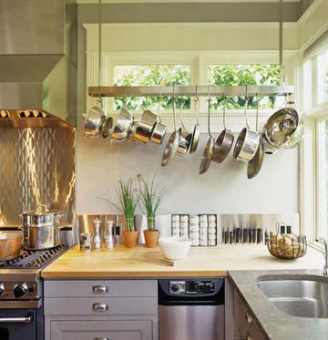 a kitchen with pots and pans hanging from the ceiling over the stove top oven