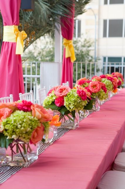 a long table with pink and orange flowers on it