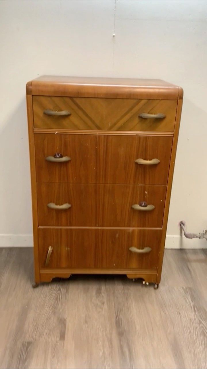 an old wooden dresser sitting on top of a hard wood floor next to a white wall