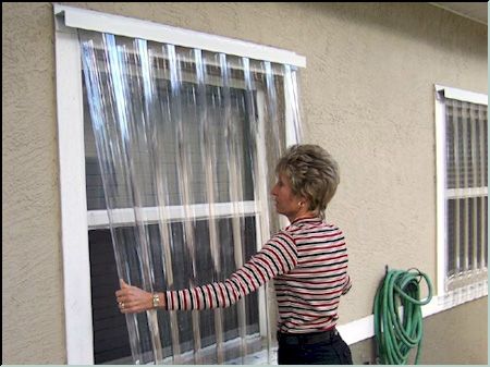 an older woman is looking out the window with her hand on the side of the house