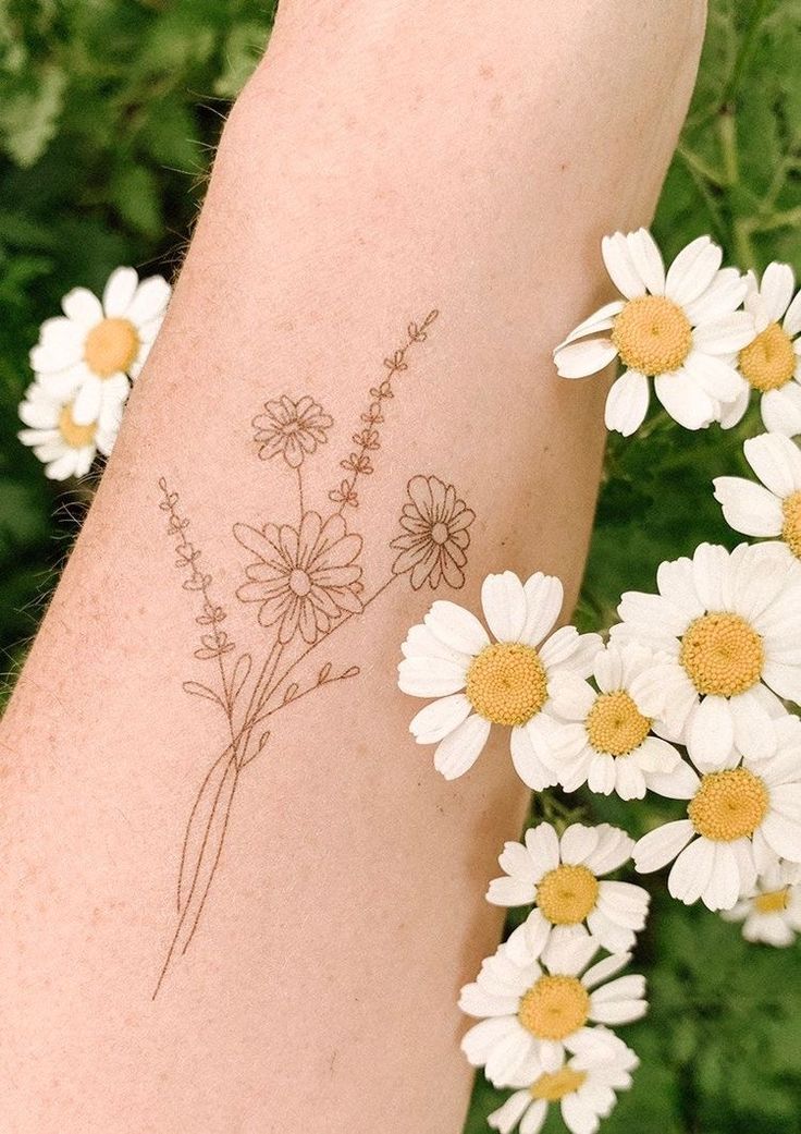 a woman's arm with daisies on it