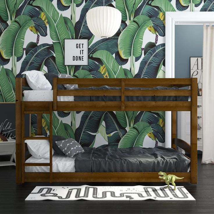 a bunk bed in front of a tropical wallpaper with green leaves on it and a white lamp hanging from the ceiling