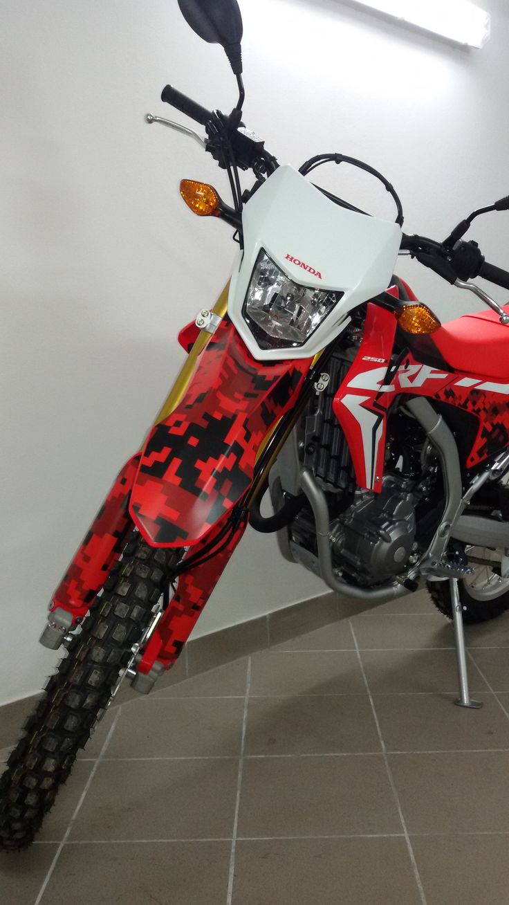 a red and white dirt bike parked in a room