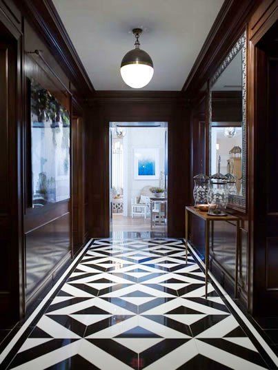 a hallway with black and white flooring next to a door leading to another room